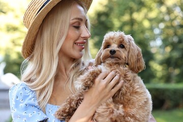 Beautiful young woman with cute dog in park