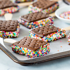 Ice cream sandwich pops on a parchment lined cookie sheet.