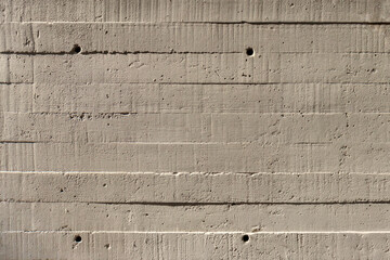 Concrete wall showing the wood imprint pattern of the planks it was formed from.
