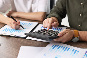Consultant working with client at table in office, closeup