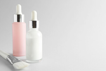 Bottles of chemical peel and brush on light background, space for text. Peeling procedure