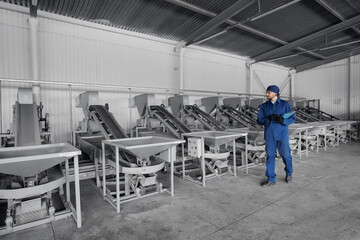 Fototapeta premium Worker engineer control automatic conveyor belt for transporting nuts. Concept check quality product on modern food industry, factory production line.