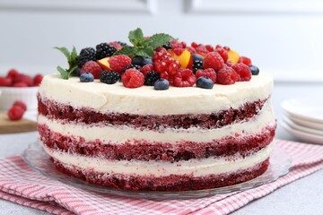 Tasty sponge cake with different fruits and mint on light grey table