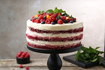 Tasty sponge cake with different fruits and mint on table