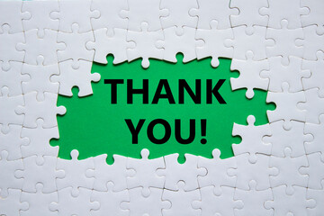 Thank you symbol. White puzzle with words Thank you. Beautiful green background. Business and Thank you concept. Copy space.