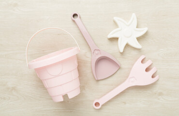 Cute toys for playing with sand on wooden background, top view
