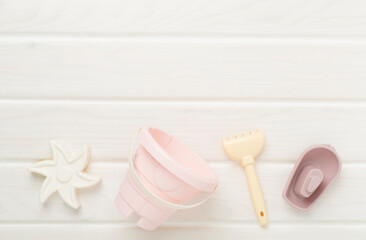 Cute toys for playing with sand on wooden background, top view