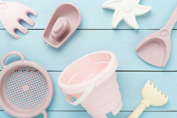 Cute toys for playing with sand on wooden background, top view