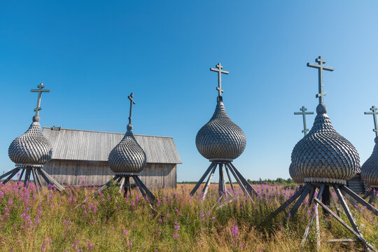 Orthodox wooden domes with Christian crosses on special shelves stand on the ground. The village of Varzuga in the north of Russia is the Kola Peninsula. natural light