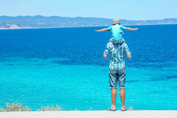 A happy father with a child near the sea in nature weekend travel