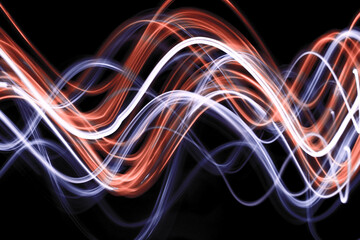 Light Painting Photography - swirly waves of neon orange and white light against a black background. Long exposure photograph. 