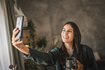 Self portrait of adult young woman, stand smile with cup of coffee