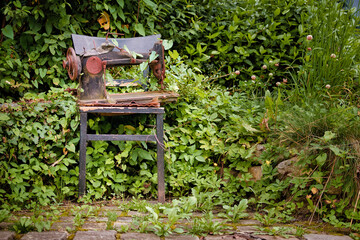 Rostige Nähmaschine als Skulptur im Naturgarten