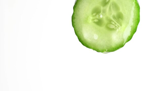 Cucumber serum and molecule gel drips from cucumber slice on white background.