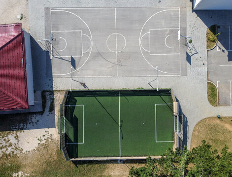 Aerial drone view of basketball and tennis field in front oh the school.  