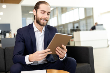 Businessman working on digital tablet at the office of car showroom