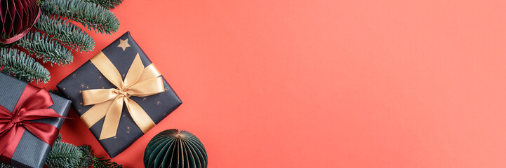 Christmas banner with gifts and fir branches on red background. Top view, copy space