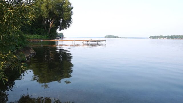 Calm water with ripples and cottage jetty on the west shore of Lake Simcoe, Ontario, Canada