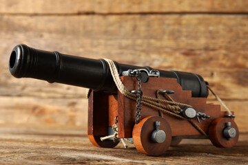 Obraz premium Toy model of cannon on wooden background