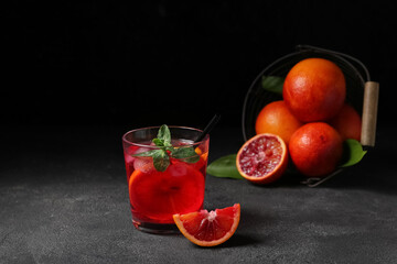 Glass of tasty blood orange lemonade on dark background