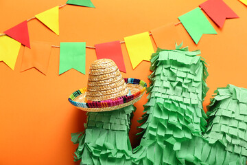 Mexican pinata with sombrero hat and flags on color background, closeup