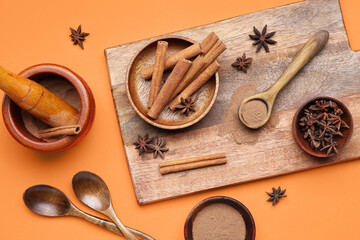 Composition with cinnamon sticks, powder and anise stars on color background
