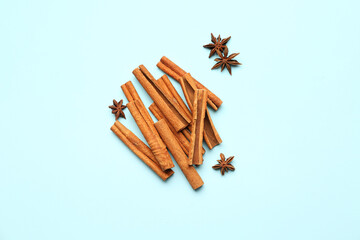 Cinnamon sticks and anise stars on color background
