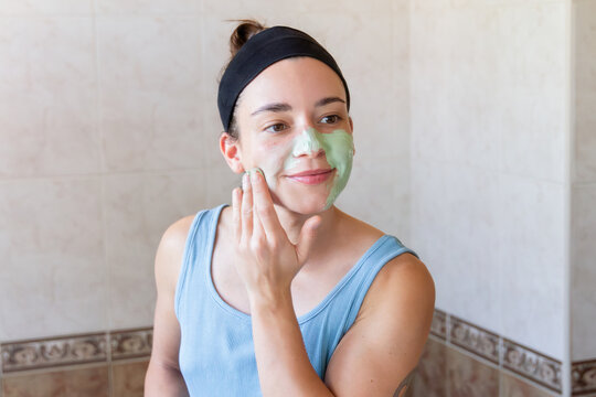 Woman applying facial mask during self-care routine