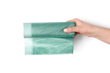 Female hand holding roll of garbage bags on white background