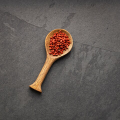 Bixa Orellana - Organic red annatto seeds in a spoon