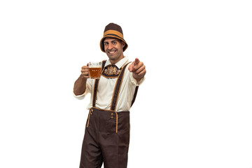young Bavarian man dressed in traditional attire, holding a glass of beer and pointing jovially at the camera during Oktoberfest white background