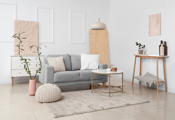 Comfortable sofa, coffee table and bamboo plant in interior of living room