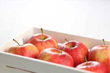 Juicy red apples in a white wooden box