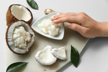 Female hand, stone tray and bowl with natural coconut oil on white background, closeup