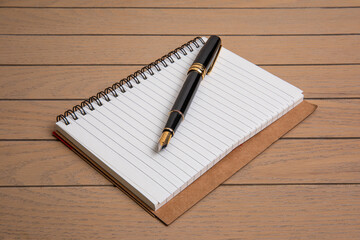 black fountain pen on thick cover notebook