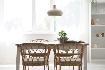 Interior of dining room with wooden table, chairs and hanging lamp