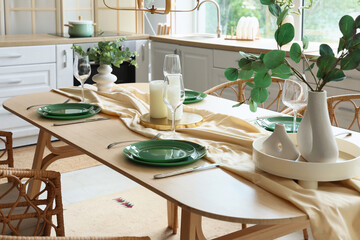 Dining table with beautiful setting in interior of kitchen
