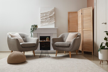 Interior of living room with armchairs, fireplace and soft carpet