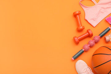 Sport equipment with body massage roller and basketball on orange background. Top view