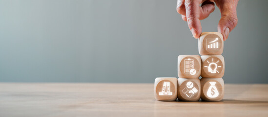 Hand stacking wooden blocks with icons representing business due diligence, financial analysis, and strategic planning.