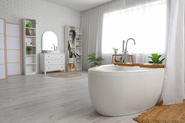 Bathtub with curtain, wooden tray and houseplants in interior of modern bathroom