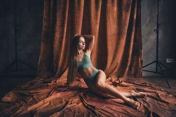 Full length photo no retouch of charming lady in khaki bra and panties lying floor looking inspired isolated on brown textile background