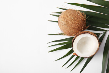 Fresh coconuts and palm leaf on white background