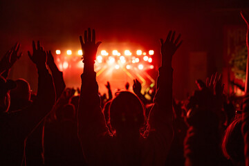 Cheering audience at some concert, backlit, red background
