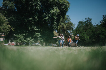 Fototapeta premium A lively group of friends running together and having fun in a lush green park on a sunny day.