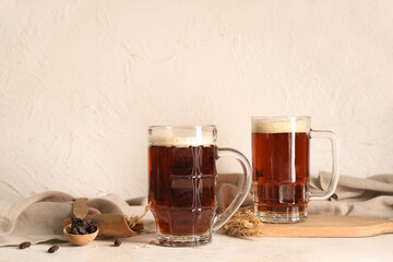 Glasses of fresh kvass and wheat on white background