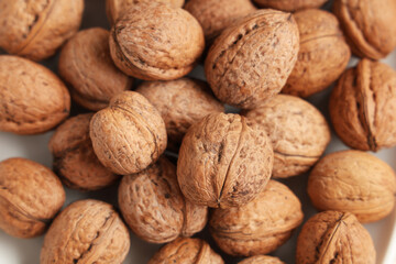 Many tasty walnuts on white background, closeup
