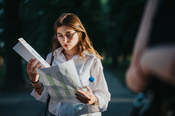 Businesswoman reading documents while standing outdoors, deeply focused on paperwork, depicting the...