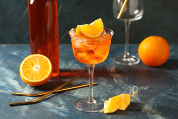 Glass of Aperol spritz cocktail on blue background