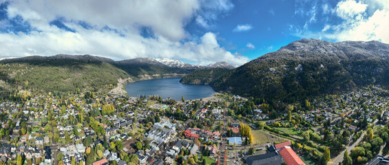 Aerial panoramic view of lakeside town San Martin de los Andes nestled between forested hills and snow-capped mountains. Patagonia Argentina